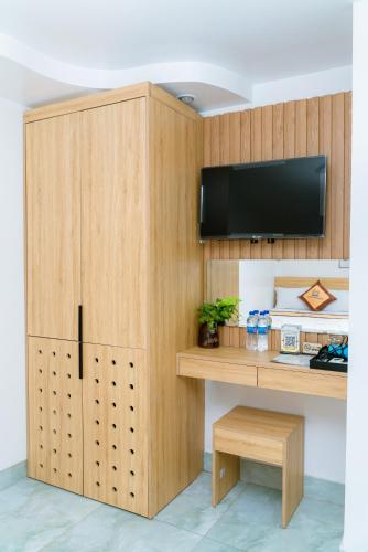 a room with a wooden cabinet with a tv on it at Sea Dragon Hotel Cát Bà & Aparment in Cat Ba