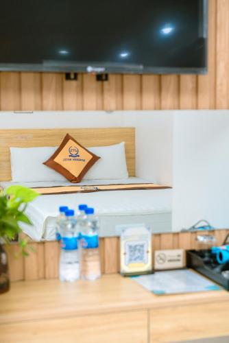 a bedroom with a bed and two bottles of water at Sea Dragon Hotel Cát Bà & Aparment in Cat Ba