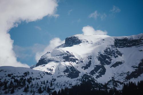 a mountain covered in snow and clouds in the sky at Hidden Retreats The Signature in Brienzwiler