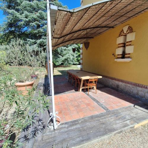 a patio with a table and an umbrella at La villa Hortense in Valençay