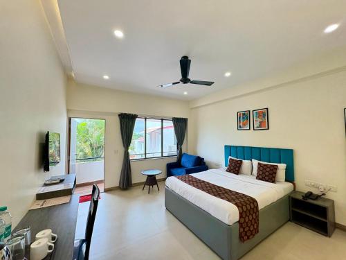 a bedroom with a bed and a blue chair at Girivihar Holiday Club - Pure Veg in Lonavala