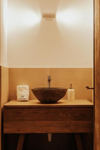 a bathroom with a bowl sink and a mirror at Hidden Retreats The Signature in Brienzwiler