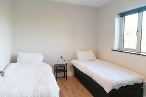 two beds in a room with a window at Willow Valley in Monaghan