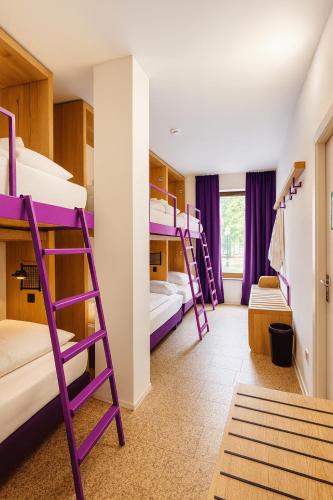 a room with purple bunk beds in it at Hotelkonkurrenz Hostel in Nürnberg