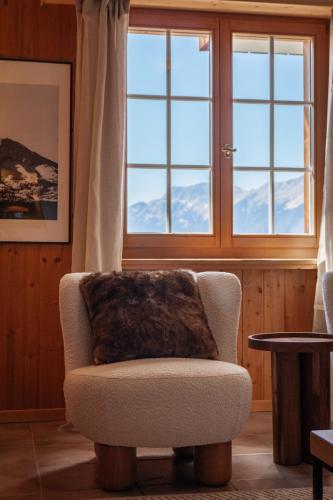 a living room with a chair and a window at Hidden Retreats The Signature in Brienzwiler