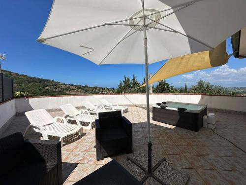 Antica Sorgente villa في أغروبولي: فناء به كراسي بيضاء ومظلة