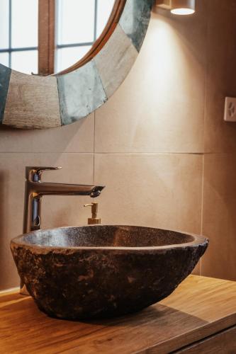 a bathroom with a stone sink and a mirror at Hidden Retreats The Signature in Brienzwiler