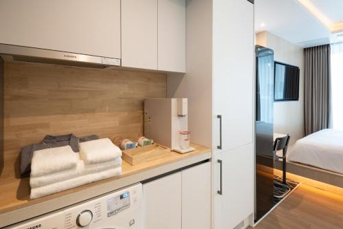 a room with a bed and a washing machine at Stayfy Paju K-hills in Paju