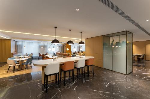 a kitchen and dining room with tables and chairs at Holiday Inn Express Lijiang Ancient Town by IHG in Lijiang