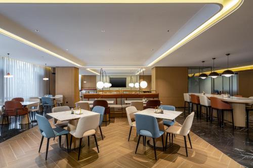 a restaurant with tables and chairs and a bar at Holiday Inn Express Lijiang Ancient Town by IHG in Lijiang