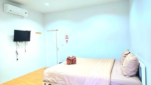 a bedroom with a bed and a flatscreen tv at Suanvadee Resort สวนวดี รีสอร์ท in Don Sak