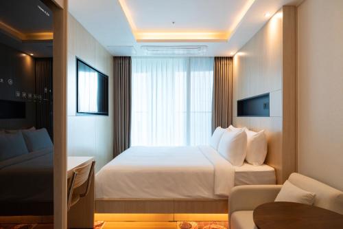 a hotel room with a bed and a window at Stayfy Paju K-hills in Paju