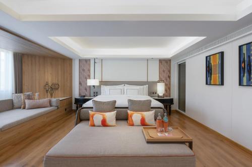 a living room with a bed and a couch at Melia Chiang Mai in Chiang Mai