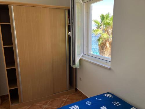 a room with a window and a bed and a door at Apartment Andrea in Sutivan