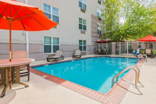 a pool with a table and chairs and an umbrella at TownePlace Suites by Marriott Springfield in Springfield