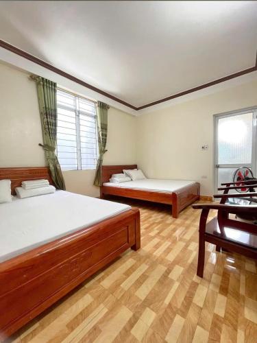 a large room with two beds and a window at Hồng Thu Hotel in Hoàng Ngà