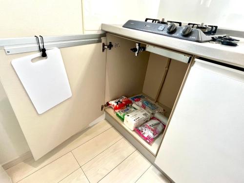 a kitchen with a sink and an open cabinet at とすアジュール in Tosu