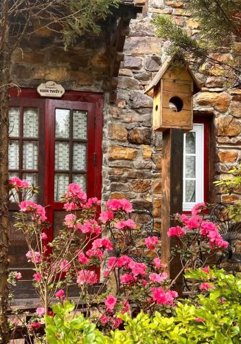 a house with a red door and a bird house at Khu nghỉ dưỡng Ba Hạt Dẻ in Sóc Sơn