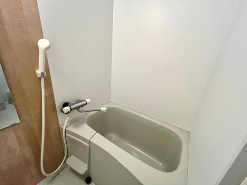 a bath tub with a hose attached to a wall at とすアジュール in Tosu