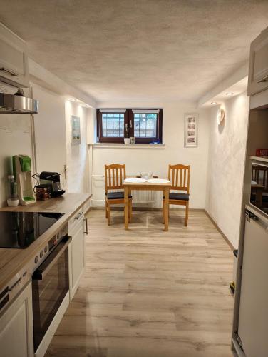 een keuken en eetkamer met een tafel en stoelen bij Ferienunterkunft in Fuldabrück