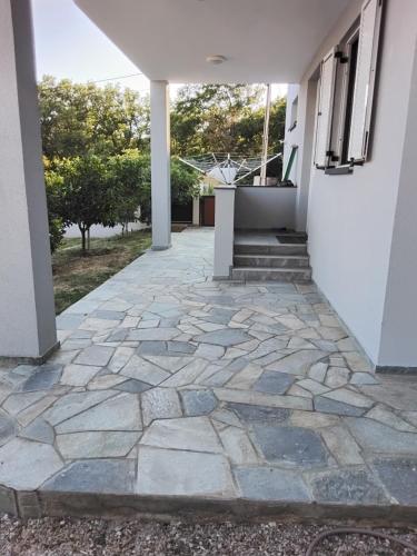 a stone walkway in front of a house at Apartmani Sutomore Tri Palme in Sutomore
