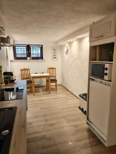 a kitchen and dining room with a table and a refrigerator at Ferienunterkunft in Fuldabrück