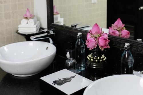 a bathroom with a sink and a toilet and a mirror at Shinta Mani Angkor in Siem Reap