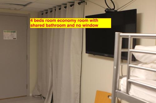 a room with a tv and a bed with a curtain at Hotell Bromma in Stockholm