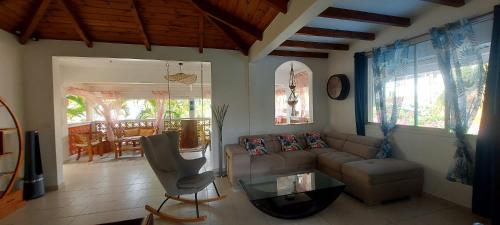 a living room with a couch and a glass table at Villa bord de mer - Piscine privée in Les Trois-Îlets