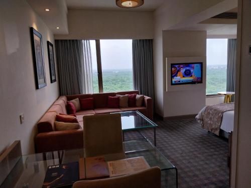 a hotel room with a couch and a bed at Efcee Sarovar Premiere Bhavnagar in Bhavnagar