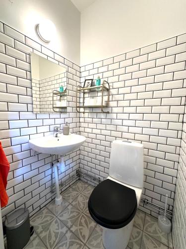 a bathroom with a black toilet and a sink at Genuint hus i Höganäs hamn in Höganäs