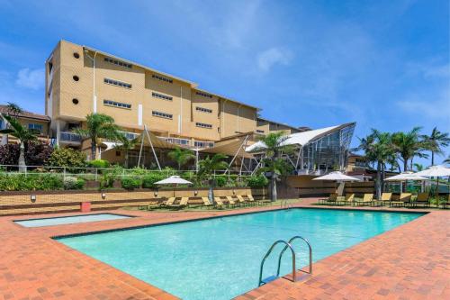 a swimming pool in front of a building at Protea Hotel by Marriott Karridene Beach in Amanzimtoti