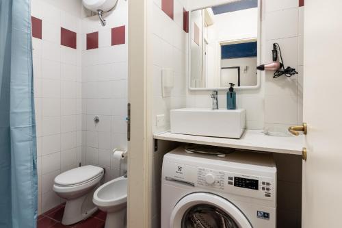a bathroom with a washing machine and a sink at Griffoni Home in Bologna