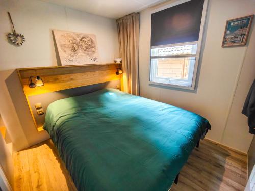 a bedroom with a large green bed in a room at Mobilhome 6p camping le bois dormant in Quend-Plage