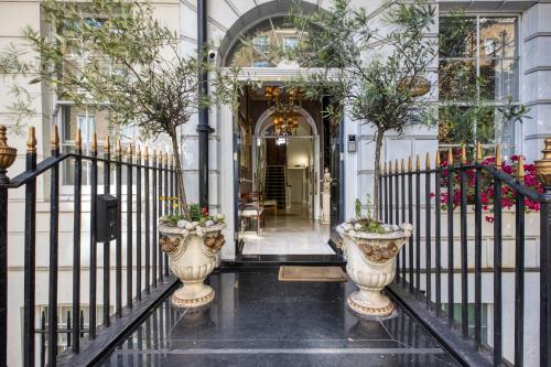 an entrance to a building with two vases at Opulence Boutique Hotel in London