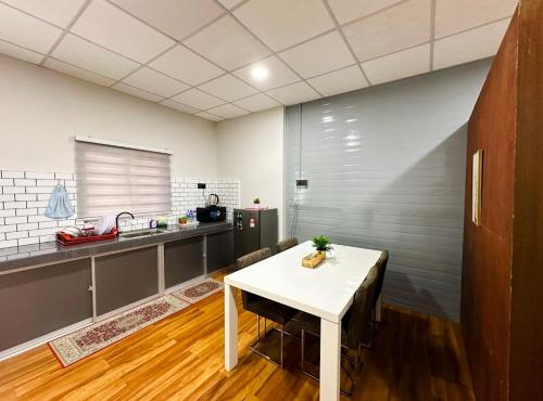 une cuisine avec une table blanche et un comptoir dans l'établissement Qudwah Stay, 