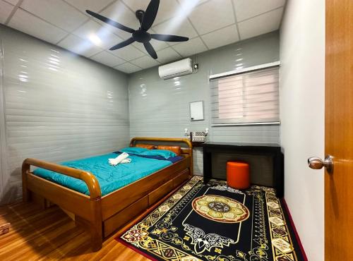 une chambre avec un lit et un ventilateur de plafond dans l'établissement Qudwah Stay, 