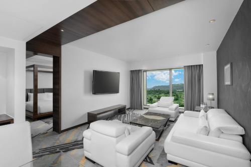 a living room with white furniture and a flat screen tv at Country Inn & Suites By Radisson Navi Mumbai in Navi Mumbai