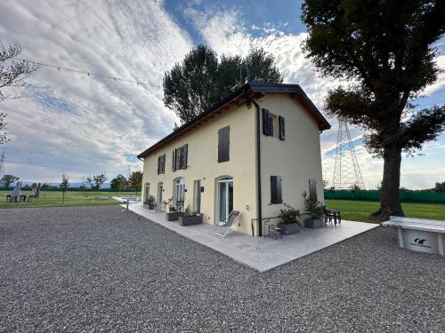 a small white building with a tree and a field at Villa Iris in Modena