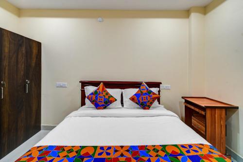 a bedroom with a bed and a wooden cabinet at FabHotel PVR in Hyderabad