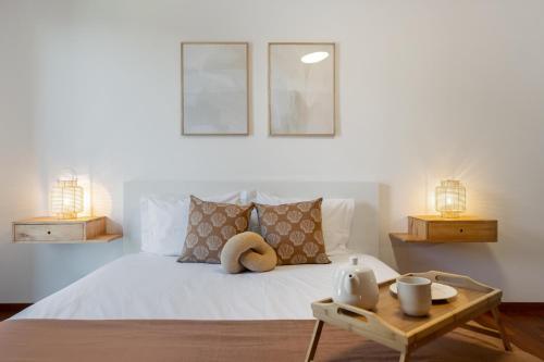 een slaapkamer met een bed met 2 lampen en een tafel bij Wings Apartment II by An Island Apart in Santa Cruz