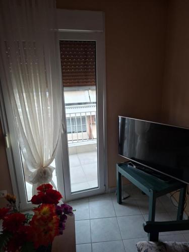 a living room with a television and a sliding glass door at Zoesappartment in Perea