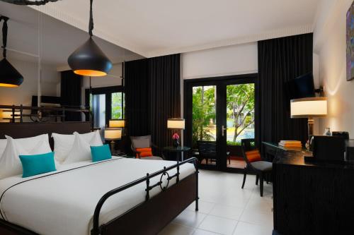 a bedroom with a bed and a living room at Shinta Mani Angkor in Siem Reap