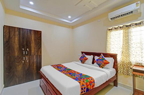 a bedroom with a bed and a window at FabHotel PVR in Hyderabad