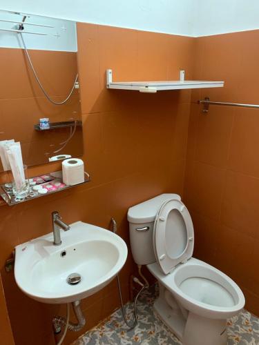a bathroom with a toilet and a sink at Route 76 Guest House in Sen Monorom
