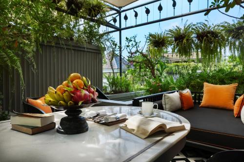 a bowl of fruit on a glass table on a patio at Shinta Mani Angkor in Siem Reap
