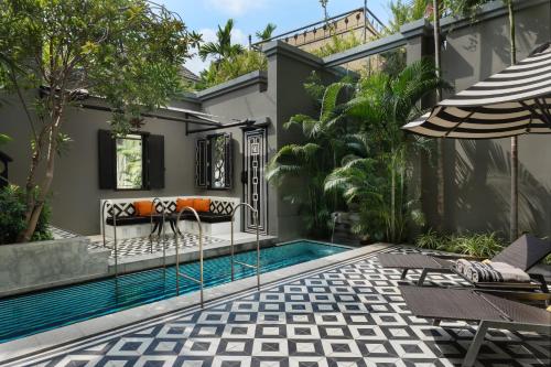 a patio with a swimming pool and a house at Shinta Mani Angkor in Siem Reap