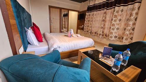 a room with a bed and a couch and a table at Hotel Green View McLeod Ganj in Dharmsala