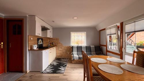 a kitchen and dining room with a table and a couch at Pokoje Wczasowe Barbara in Ustka