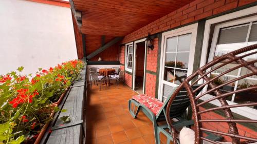 a balcony of a house with a bench and flowers at Pokoje Wczasowe Barbara in Ustka
